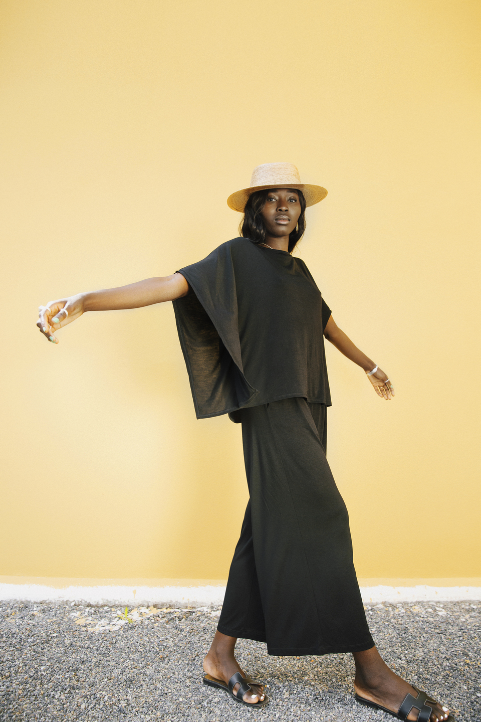 AWAN black wide-leg set against a yellow wall